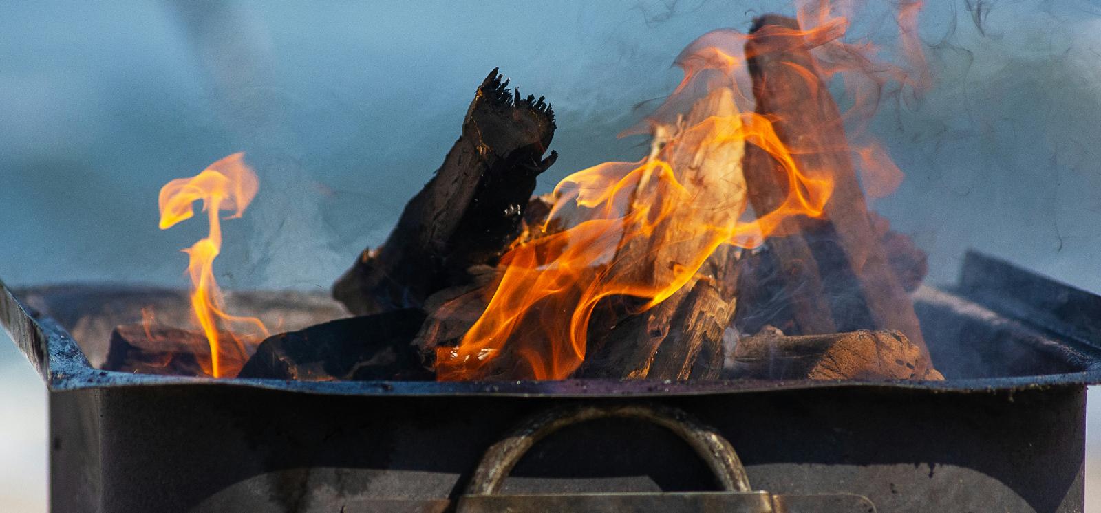 Chicken and boerewors on a braai grid over glowing coals